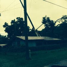 A house with power lines hanging from it's roof.