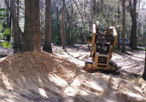 A yellow tractor is parked on the dirt